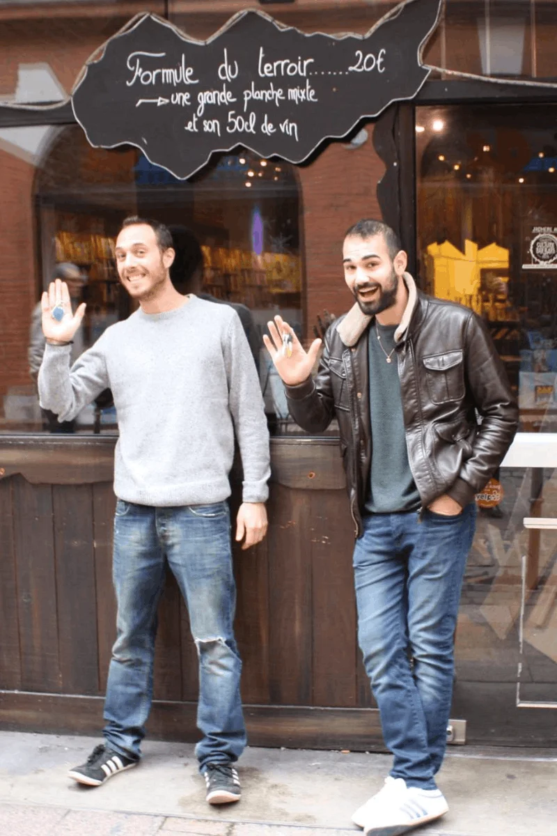 Mateo et Jonathan, créateurs du bar à tapas BOCA à Toulouse, posent fièrement devant leur vitrine, clés en main, prêts à faire rayonner leurs montaditos et leur concept en France.