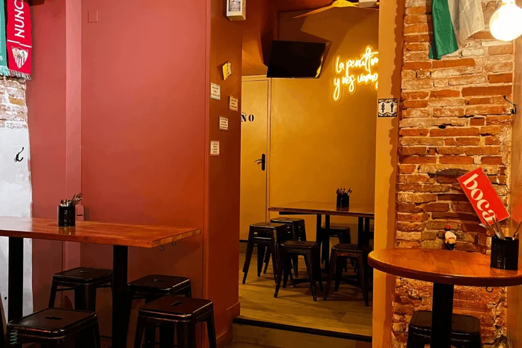 Espace intimiste du bar à tapas BOCA à Toulouse : salle secondaire avec coin pour petits groupes (2-3 personnes) et grandes tablées pour 5 à 10 convives, parfait pour les dîners ou les apéros entre amis.